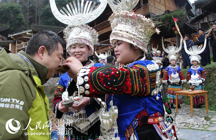 2015年2月22日，到郎德苗寨的游客在体验十二道拦门酒。李雪 摄