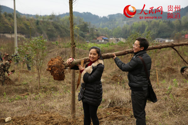 2月25日，在滨河公园植树造林现场，2名志愿者在抬树苗。杨希 摄