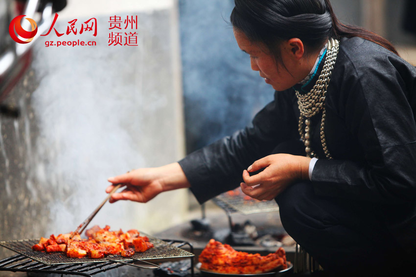 贵州省从江县加榜乡下尧村的壮族妇女在烤香猪肉。