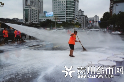 洒水车及环卫工人正在冲洗路面。