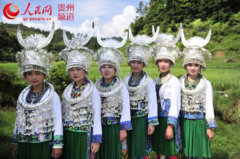 8月6日，从江县斗里乡马安村闹鱼节上，苗族姑娘们前去看热闹。（梁光源 摄）