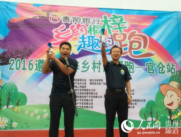 桐梓县文体广播新闻出版局局长李念（右），官仓镇党委书记娄立峰（左）扣响体验组发令枪。