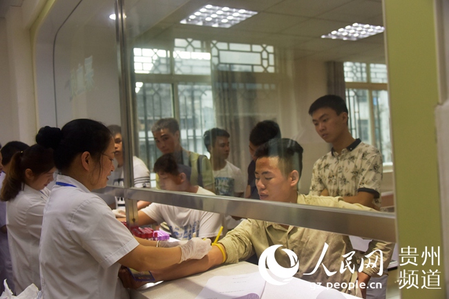 8月9日,应征入伍男青年在贵州省从江县征兵体检站参加体检.