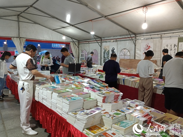 贵阳市民在书摊上选择书本。王钦 摄