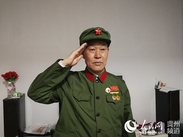 每逢"八一"建军节,田正洪穿上绿军装向党旗行军礼.三角坝村党支部供图