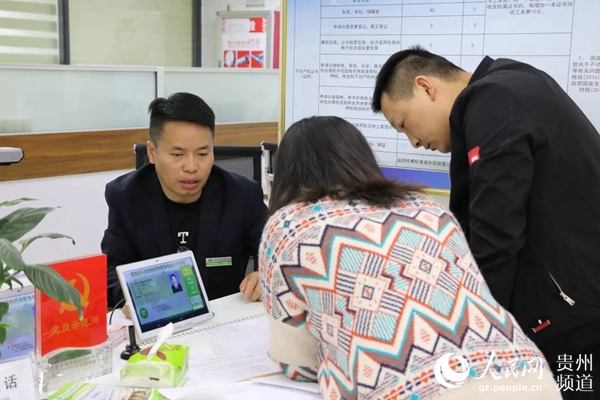 黨員示范崗盧銀輝為群眾辦理業務。荔波縣委宣傳部供圖