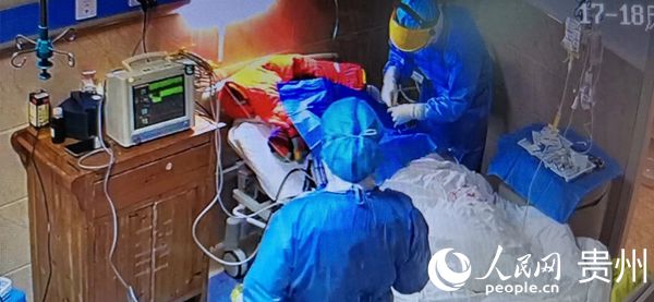 “全副武裝”的麻醉醫師滕棉和腎內科醫師潘群為患者進行深靜脈置管。中共銅仁市委宣傳部提供