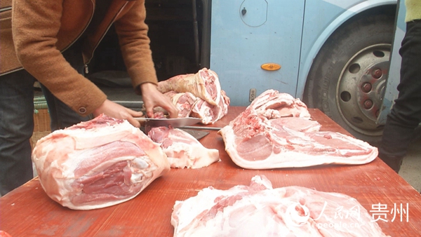 菜商正在給前來買菜的居民割肉
