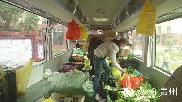 領到號牌的居民在流動菜市挑菜