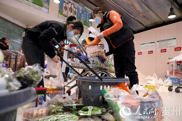 超市工作人員正在打包線上下單的食材和生活用品。丁偉鑫 攝