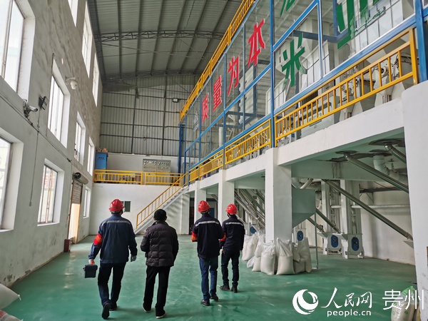 在遵義鳳岡縣宏發米業有限公司，經理夏可剛向供電人員介紹復工生產情況。龔紅 攝