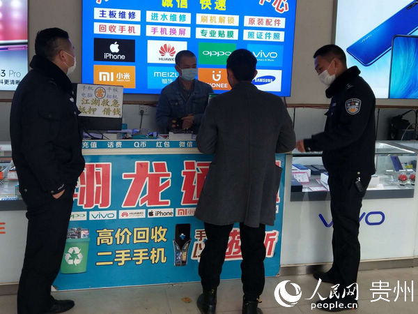 后寨派出所民警陳棟在手機店巡查並向群眾做防疫宣傳。秦海艷 攝