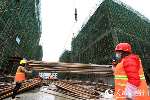 南明電子信息產業園的施工工人正在通過塔吊超重設備吊運施工鋼管。趙鬆 攝