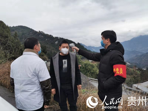 劉杰在村級卡點對進出人員 進行體溫監測