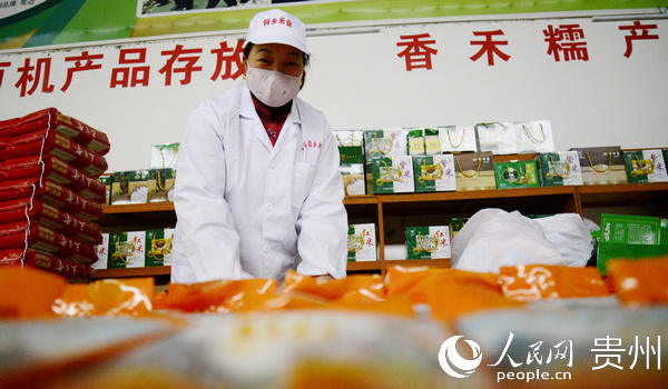 2月20日，在黎平縣德鳳街道侗鄉米業生產車間，一名工人在整理包裝好的大米。