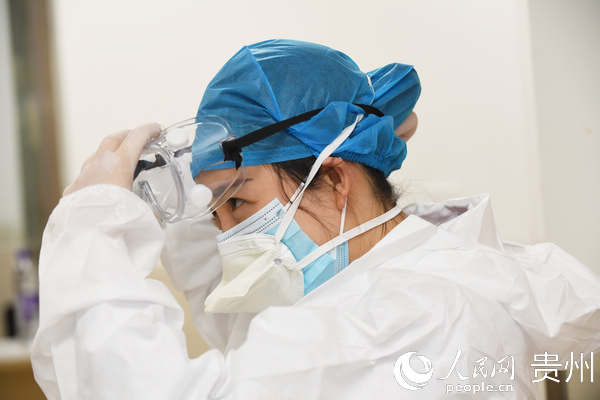 3月6日，貴陽市南明區人民醫院體檢科主任陳娟正在穿戴防護服，准備為外地來筑人員進行新冠肺炎核酸採樣。趙鬆 攝