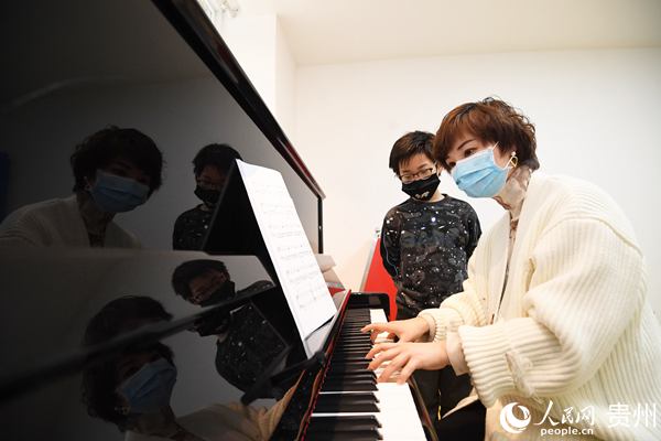 3月23日，在貴州省貴陽市南明區文化館，鋼琴老師正在給一位小朋友作演奏示范。趙鬆 攝