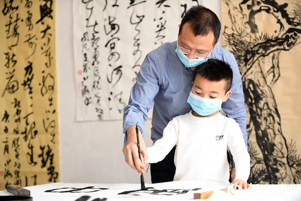 3月23日，在貴州省貴陽市南明區文化館，一位小朋友正在老師的指導下進行書法習作。趙鬆 攝