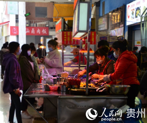 在花果園商業步行街，一家小吃店工作人員正在為顧客制作餐食。王秀芳 攝