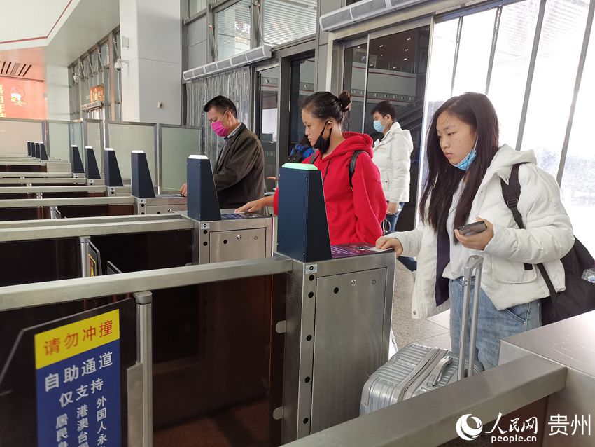 圖為4月5日當天，旅客在貴陽北站西廣場進站口，脫下口罩進行人臉識別自助檢票業務。劉江 攝