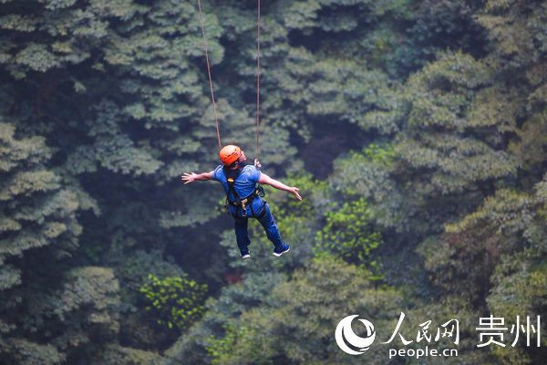 “五一”期间游客在开阳县猴耳天坑景区体验大秋千项目。
