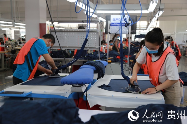 2020年5月7日，貴州省畢節市黔西縣岔白工業園區一家服裝企業的扶貧車間，員工在熨燙服裝。  史開心 攝