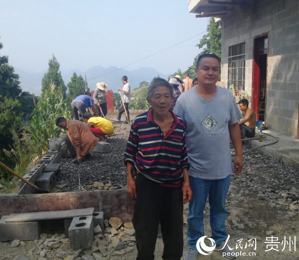 單正方（右）與群眾在院壩硬化施工現場。劉繼明 攝
