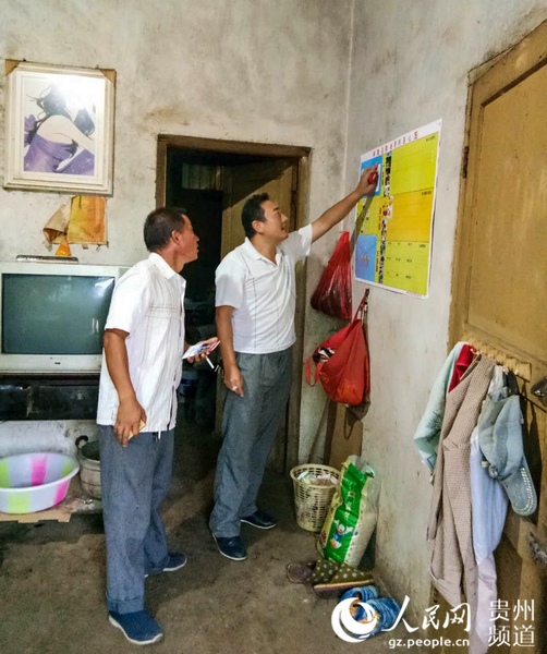 李紹山生前在樹林組李萬祥家查看連心圖。赫章縣委宣傳部供圖