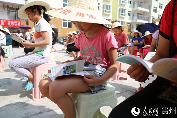 現場群眾在閱讀《貴州省未成年人保護法律知識通俗插畫讀本》。