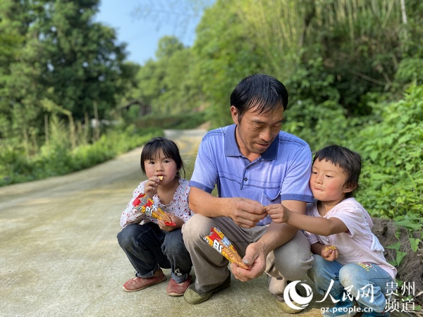農忙回來的況學軍為兩女兒帶來零食