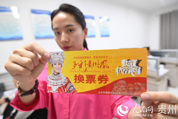 南明區文體廣電旅游局工作人員展示贈送給抗疫一線工作人員的《多彩貴州風》文化演出券。