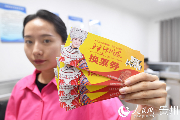 南明區文體廣電旅游局工作人員展示贈送給抗疫一線工作人員的《多彩貴州風》文化演出券。
