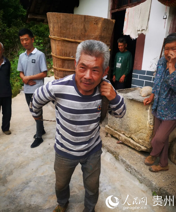 魚塘村村民演示用背桶取水。王安宏 攝