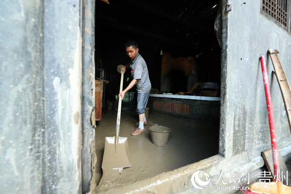 村民正在清理家中的淤泥。胡攀學  攝
