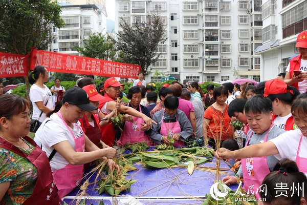 社區組織黨員志願者在小區開展“鄰裡親”共端午包粽子活動。