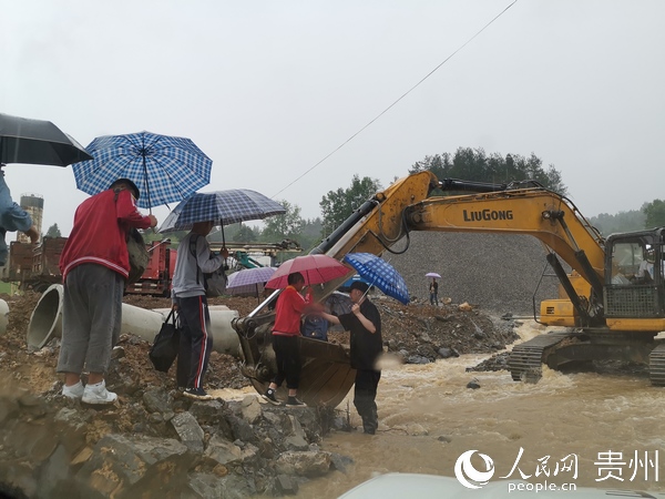 中考考生路遇洪澇， 民警挖掘機安全護送。