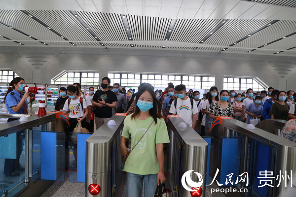 2020年6月27日，貴州省畢節市黔西高鐵站迎來端午節后返程小高峰，乘客在工作人員的組織下有序檢票通過檢票口。陳龍 攝
