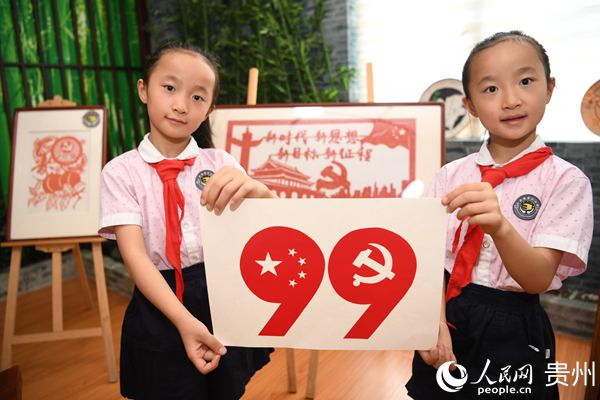 6月30日，貴州省貴陽市南明區花果園第三小學的兩名小學生展示手工制作的慶祝中國共產黨成立99周年剪紙圖案。