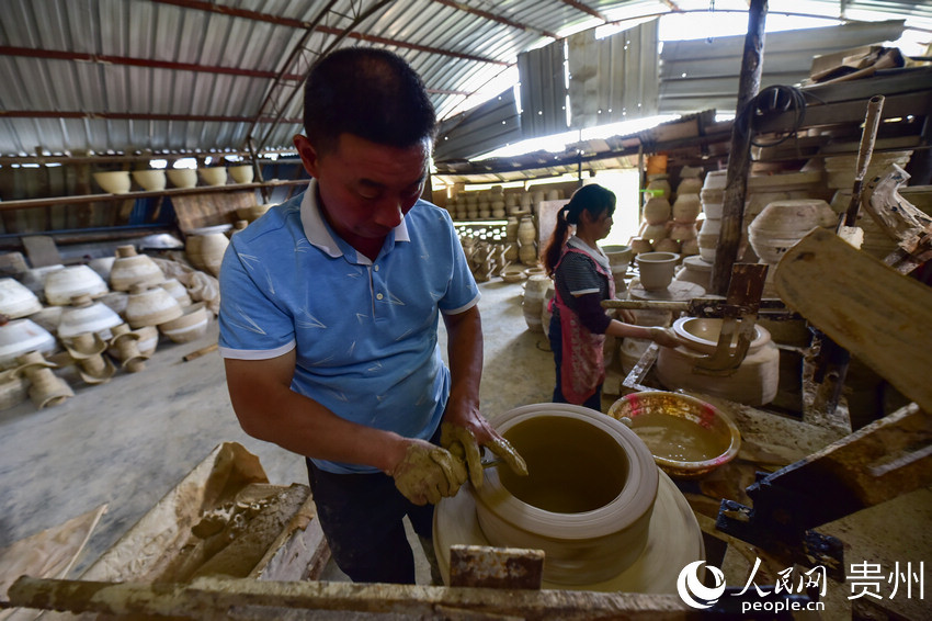 7月4日，張忠祥（左）在自己的土陶作坊裡制作陶坯。