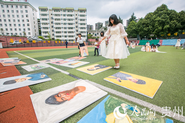 7月4日，學生從貴州省畢節市民族中學足球場上的畫像前走過。