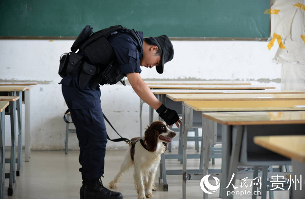 民警攜警犬進行考試前安檢搜爆工作。