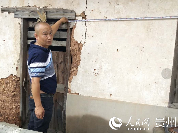康明剛在查看村民房屋因地災受損的情況。管慶軍供圖