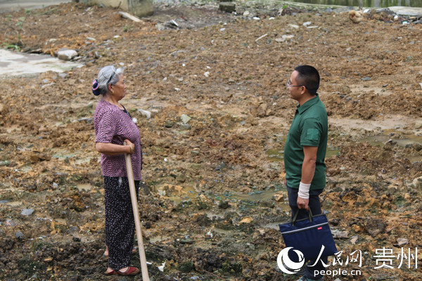 崔飛（右一）與正在復綠的村民談收入情況。楊友 攝