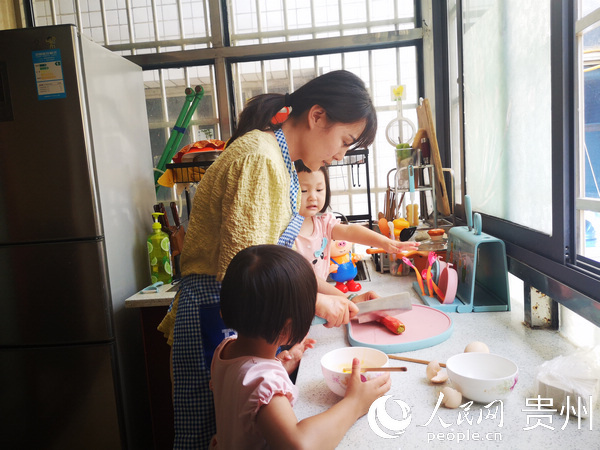 劉丹帶著兩個女兒一起煮飯。陳娟 攝