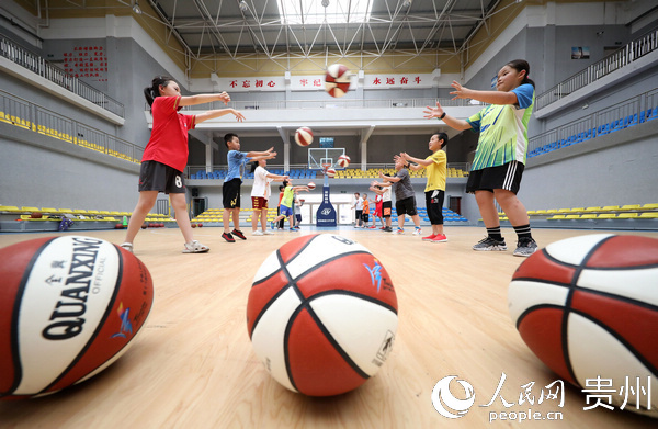 7月16日，小学员在贵州省丹寨县体育馆内练习篮球传球技术。黄晓海 摄