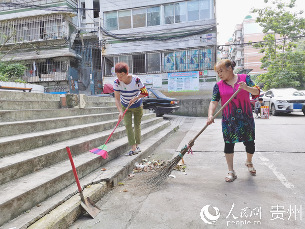 陳建英和鈳沅敏正在幫忙打掃小區衛生