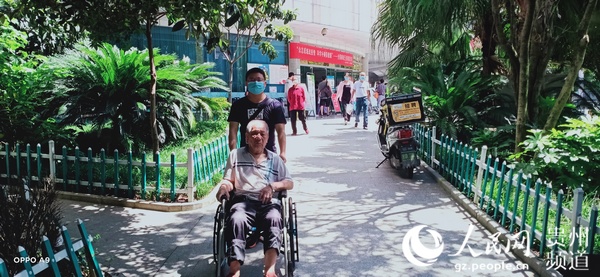 坐在輪椅上的劉日周老人出院，准備回到闊別半個世紀的家鄉