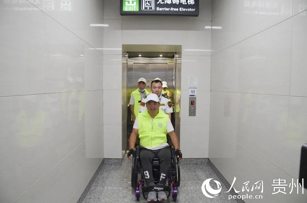 残疾人代表使用无障碍电梯进入地铁站台。张奕妍 摄