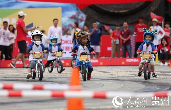 8月16日，在贵州省丹寨县万达小镇，小选手在参加平衡自行车比赛。
