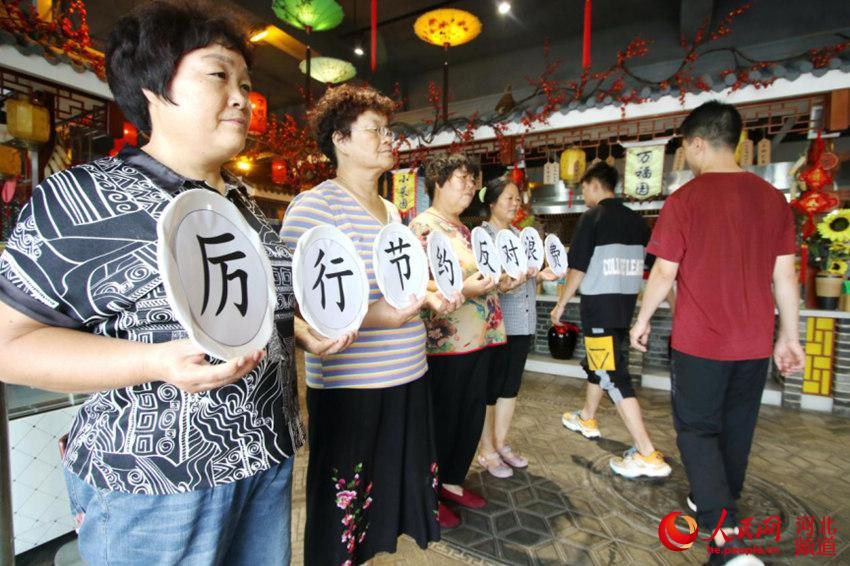 8月12日，河北省邯鄲市永年區一家餐廳的工作人員開展“厲行節約 反對浪費”倡議宣傳。 胡高雷 攝